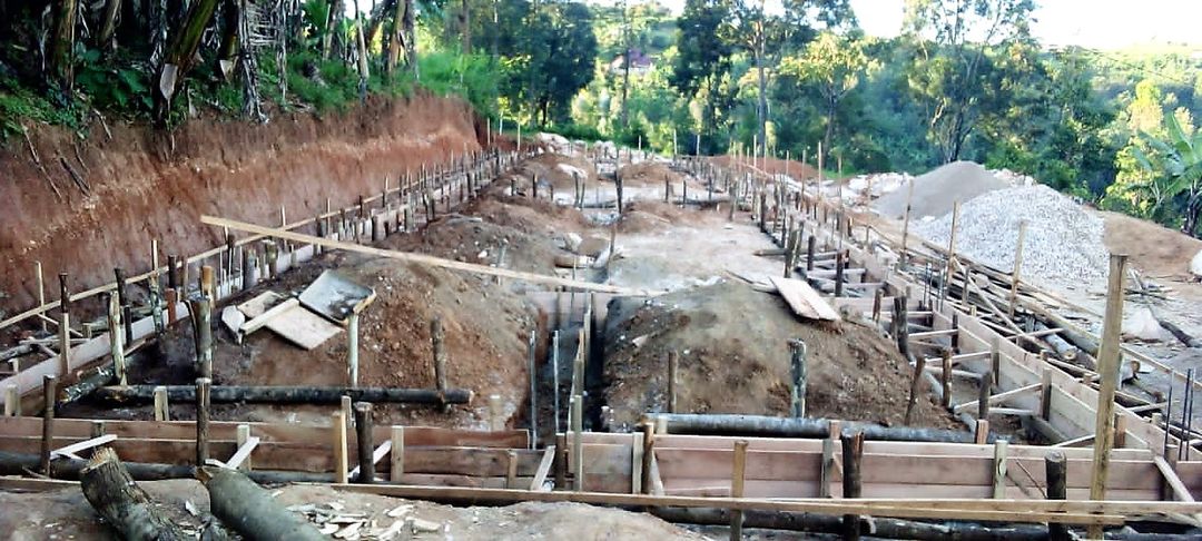 Baustelle mit Fundamentgräben und Schalung am Hang