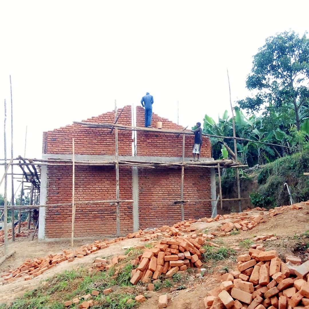 Ziegelrohbau mit Holzgerüst, Arbeiter auf dem Gerüst