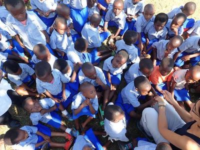 Viele Kindergartenkinder in Uniformen sitzen eng beisammen