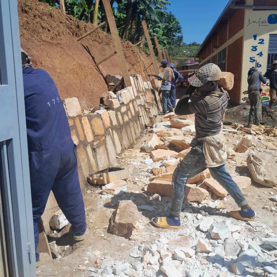 Arbeiter bauen eine Stützmauer aus Naturstein am Hang